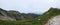 Grassy mountain range and cloudy blue horizon at Senjojiki Cirque