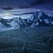 Grassy slopes and rocky peaks composite at night