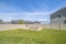 Grassy yard with view of rooftops lake and snow capped mountain under blue sky