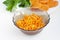 Grated carrots in a bowl, peeled and cut into pieces carrots, parsley