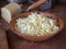 Grated cheese for making pizza in a deep bamboo plate by a large clan on table