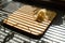 Grated cheese on wooden board. Stripes from blinds on the window casting over board with shredded cheese.