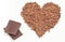 Grated chocolate in shape of heart and portion of chocolate. White background