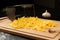 Grated fresh aromatic cheese for pizza, garlic and grater lie on a kitchen board