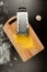 Grated fresh aromatic cheese for pizza, garlic and grater lie on a wooden board
