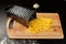 Grated fresh cheese for pizza, garlic and grater lie on a wooden kitchen board