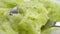 Grated fresh green zucchini in a spoon. Macro. Rotation.