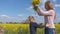 Grateful daughter gives her mother flowers in a rapeseed field.