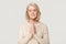 Grateful happy mature woman meditating praying isolated on background