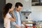 Grateful wife embracing shoulder of husband engaged in preparing salad