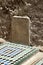 Grave and inscribed tablet  against wall in the courtyard of Saadian Tombs