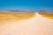 Gravel 4x4 road crossing the colorful desert at Twyfelfontein, in the majestic Damaraland Brandberg, scenic travel destination in