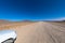 Gravel 4x4 road crossing the  desert at, in the beautiful namib Naukluft national park against blue sky. Tourism and vacations con