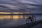 gravel bike on a shore of a frozen lake with distant view of Rocky Mountains, winter dusk in Colorado