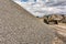 Gravel mountain with an excavator in the background