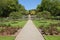 A gravel path runs between two verdant lawns before rising up several flights of steps and terraced gardens in the formal gardens