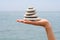 Gravel pile in woman\'s hands with sea background