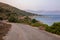 The gravel road along the coast of the Kastos island, Ionian sea, Greece in summer evening.