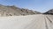 gravel road and barren slopes in hilly landscape at Moonlandscape, near Swakopmund, Namibia