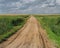 Gravel road through flat prairie.