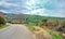 Gravel road and magnificent green grass near the road with cloudy