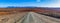 Gravel road winding through bald orange hills.