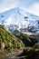 Gravel trail heading towards magnificent snow covered cone of Mt Taranaki. Egmont National Park, New Zealand