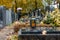 Graves on cemetery in autumn with a couple mourning the dead