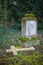 Gravestone and a tumbled down stone cross on a former cemetery