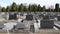 Gravestones and flowers in Catholic Cemetery. Graves and Tombstones. Black headstones in graveyard. Floral decoration and tombs. M