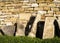 Gravestones lit by sun placed near a wall