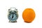 Gray alarm clock and orange isolated on a white