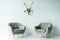 Gray armchairs and antlers on wall