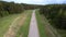 Gray asphalt road surrounded by green dense forest