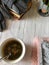 on a gray background, flower tea is next to the knitting, and next to the books is an aroma candle on which mittens lie