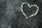 Gray background marble gloomy cement floor. Symbol heart laid out with flowers. The figure of the heart is lined with flowering
