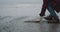 Gray beach closeup capturing video of a man have a meditation time beside of a seashore on a rain day.