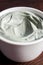 Gray bentonite clay in a bowl. Diy facial mask and body wrap recipe. Dark background, clay texture close up, copy space