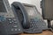 Gray and black business wired phone with receiver, dial and large display in the business office environment