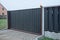 Gray black private gate and wooden plank fence