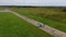 Gray blue fighter combat aircraft travels along the runway at old empty airfield on a cloudy day among green fields. Top view