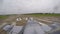 A gray blue fighter combat plane come out for the runway at the old airfield on a cloudy day against green fields.