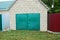 Gray brick garage with a glazed green gate in the street