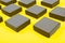 Gray bulk boxes on a yellow background. Color of the year 2021