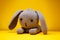 gray bunny with lowered ears on yellow background cute kids knitted toys