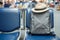 Gray business backpack with hat on seat at the interior of airport terminal. Business and Travel concept