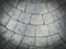 Gray cobblestone bricks floor with a curve of half-circle pattern as background texture