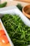 Gray Container of fresh green, natural arugula with red tomatoes