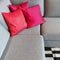 Gray corner sofa with silky red cushions