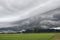 Gray Cumulonimbus cloud formations on sky above mountain, Nimbus moving with rice field,  Arcus cloud rolling in the storm